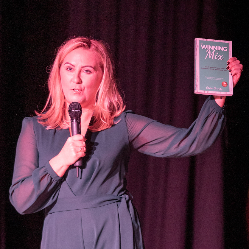 Claire Brumby holding a copy of her book "The Winning Mix"