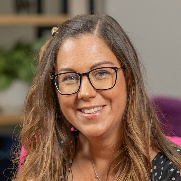 A woman wearing glasses and a polka dot top.