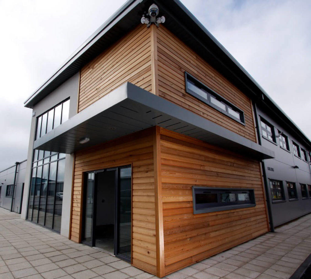 The Reception of E-Factor Village property features a building with wood siding and glass windows.