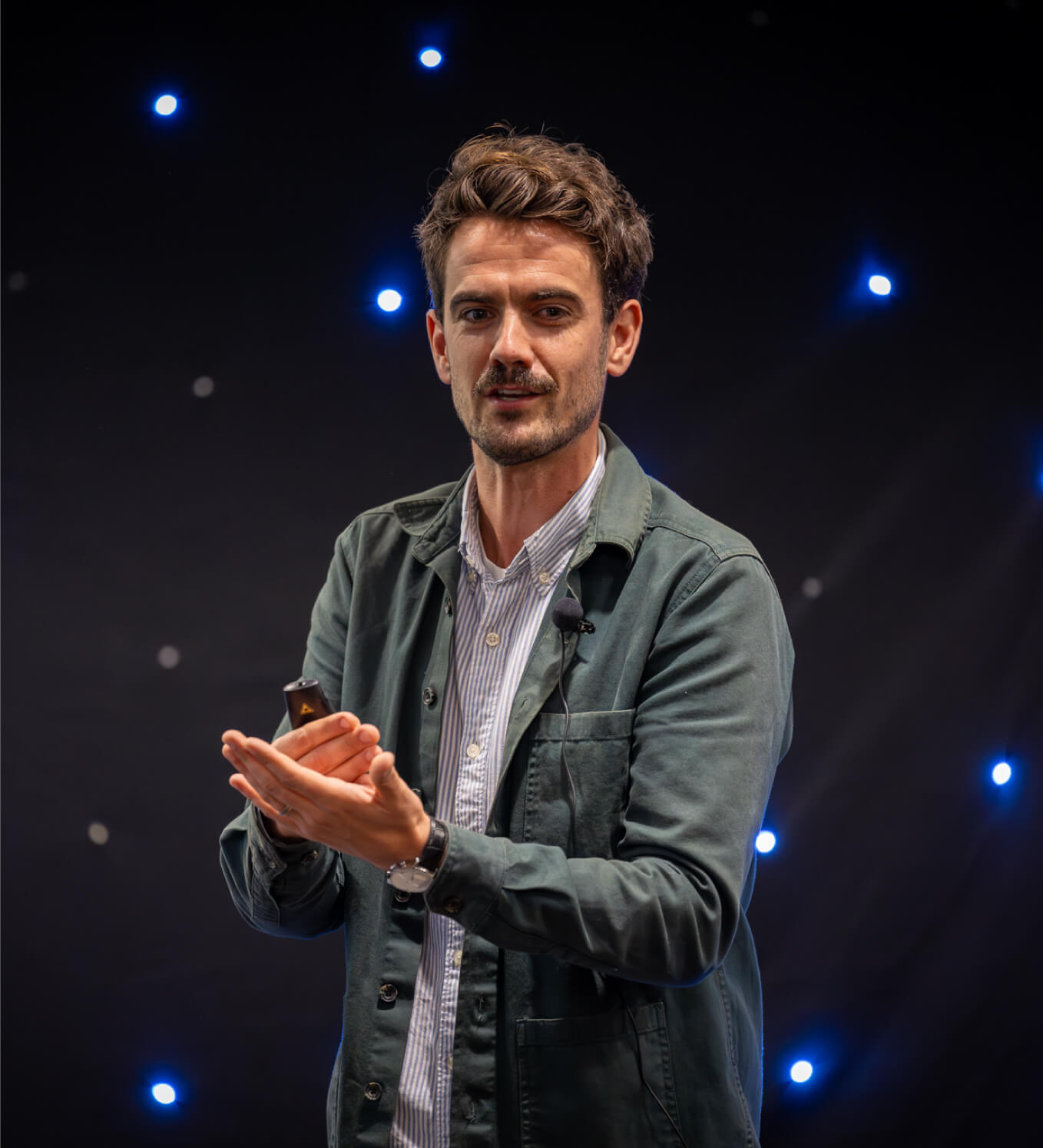 We observe a man standing in front of a starry background.